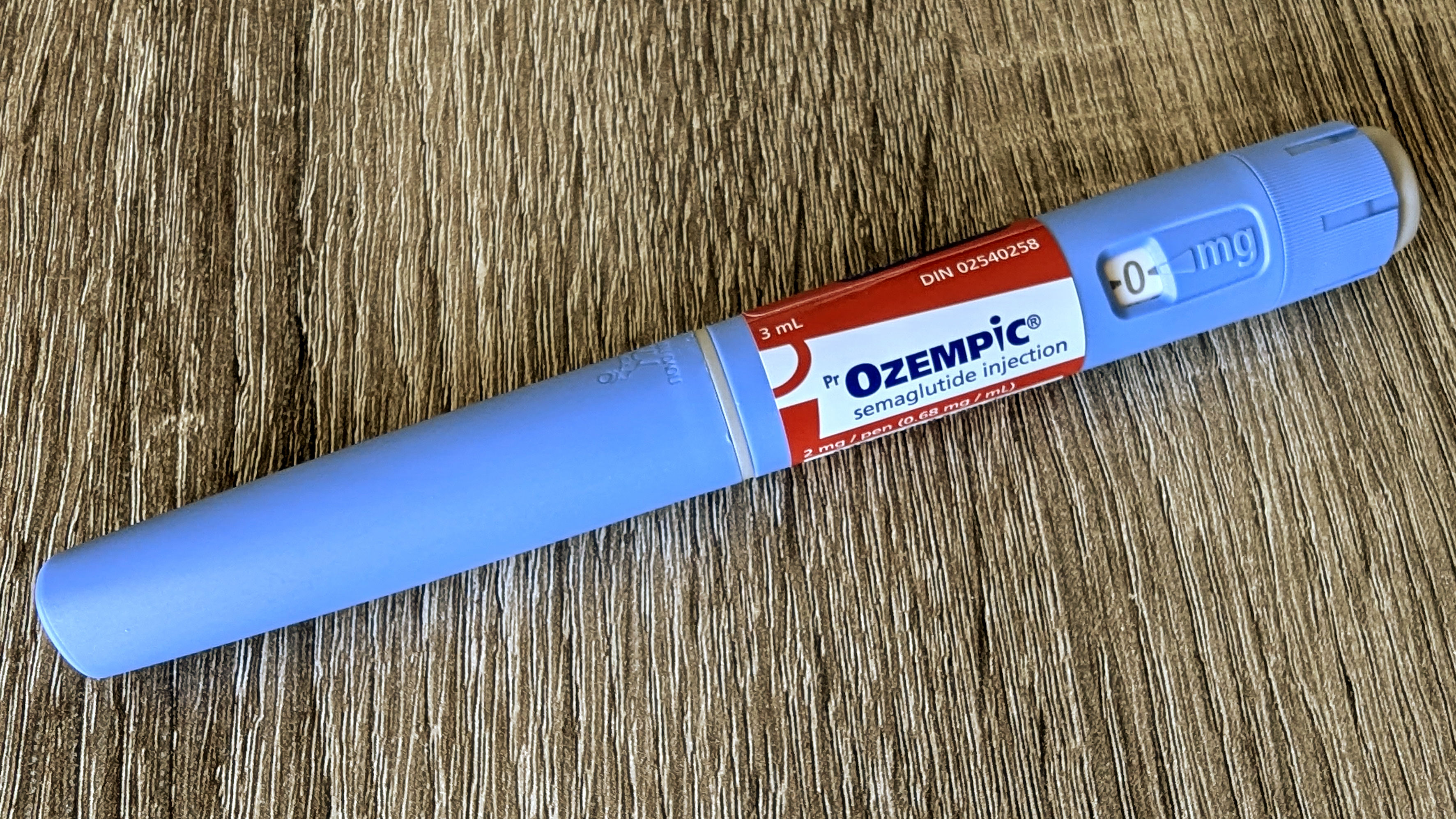 An Ozempic pen on a wooden background